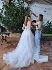 two girls are helping a bride in her wedding dress at Hotel Mision Santa Barbara in Barichara +99 photos