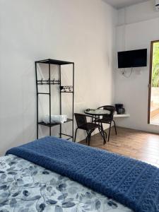 a bedroom with a bed and a table and chairs at Centro Turístico Las Palmitas in Muelle del Arenal