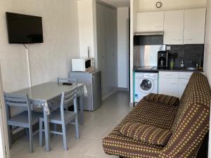 a living room with a couch and a table and a kitchen at SETE studio cabine face mer in Rémire-Camp