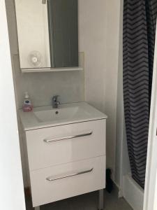 a bathroom with a white sink and a mirror at SETE studio cabine face mer in Rémire-Camp
