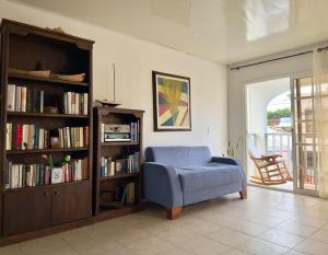 a living room with a blue couch and a book shelf at CONNOLLY'S APARTMENTS in San Andrés