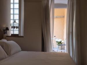 a bedroom with a bed and a window with a bird cage at Palazzo Brunamonti Boutique Hotel in Bevagna