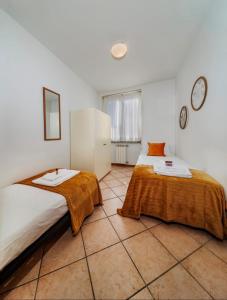 a bedroom with two beds and a tiled floor at La Finca Bellagio in Bellagio