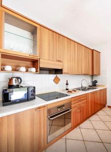 a kitchen with wooden cabinets and a stove top oven at La Finca Bellagio in Bellagio