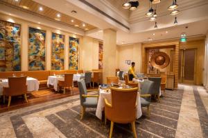 a restaurant with tables and chairs and a person in the background at DoubleTree by Hilton Agra in Agra