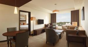 a hotel room with a living and dining room at DoubleTree by Hilton Agra in Agra