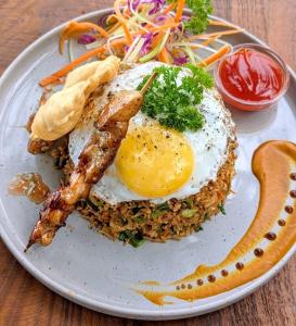 a plate of food with an egg on top of rice at Kekulama Eco Cabana Galle in Galle