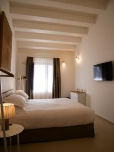 a bedroom with a large bed and a window at ORTO NOTO - Agri Resort in Noto