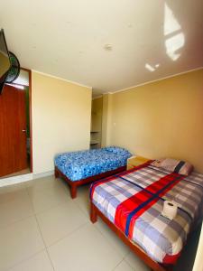 a bedroom with two beds in a room at Hospedaje De Joce in Nazca +18 photos