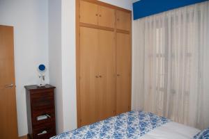 a bedroom with a bed and a wooden closet at Lucero Dos Catedrales in Zaragoza