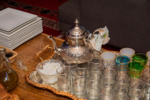 a table with a tea kettle and glasses on it at Relais Des Nomades in Tinerhir