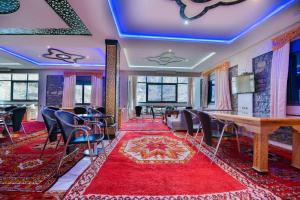 a room with a table and chairs and a red rug at Relais Des Nomades in Tinerhir