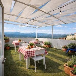 a patio with tables and chairs and a view of the mountains at Paradice in Baunei in Baunei