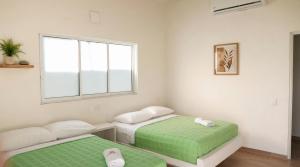 a white room with two beds and a window at Acaymas Club in Ricaurte +38 photos