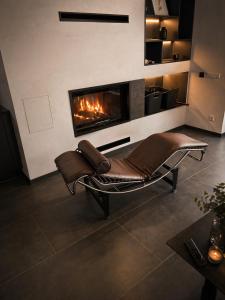 a leather chair in a living room with a fireplace at Chalet Beyond in Veľká Lomnica