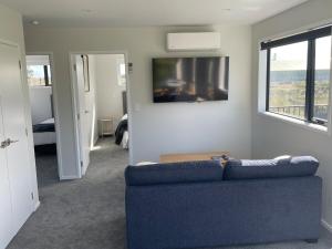a living room with a blue couch and a window at Blacksmith's Rest in New Plymouth