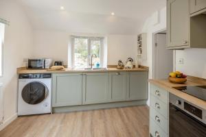 a kitchen with white cabinets and a dishwasher at 2 Bed in Chideock oc-c36616 in Chideock