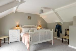 a bedroom with a white bed and two chairs at 2 Bed in Chideock oc-c36616 in Chideock