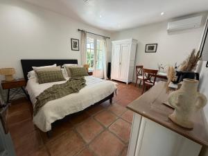 a bedroom with a bed and a table in it at Chambres et tables d'hôtes , spa et séjour bien être , Le Clos de la Chèvre Sud in La Cadière-dʼAzur +61 photos