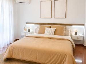 a bedroom with a large bed with two pictures on the wall at Apartamento Laurencia in Fuente Obejuna