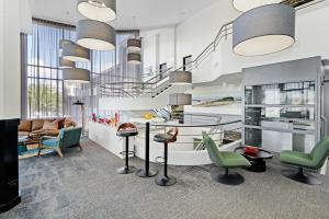a lobby with green chairs and a table and stairs at BEST WESTERN PLUS Apollo Hotel Newcastle in Newcastle
