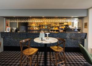 a table and two chairs in front of a bar at BEST WESTERN PLUS Apollo Hotel Newcastle in Newcastle +31 photos