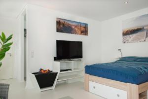 a bedroom with a bed and a tv on a wall at Apartments Leverkusen City in Leverkusen