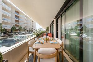 a balcony with a table and chairs in a building at Riva Waterfront in Olhão