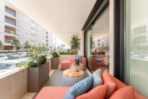 an apartment patio with orange furniture and plants at Riva Waterfront in Olhão