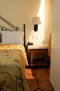 a bedroom with a bed and a table with a lamp at Hotel Hacienda del Sol in Tonalá