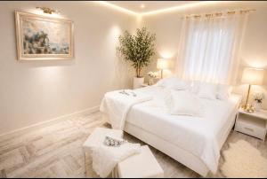 a white bedroom with a large bed with white sheets at Relax Villa with Pool in Bihać +6 photos