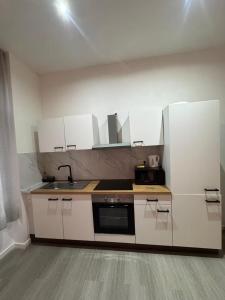 a kitchen with white cabinets and a sink at Stylish 1BR Apartment with Sofa Bed in the Heart of Liège in Liège