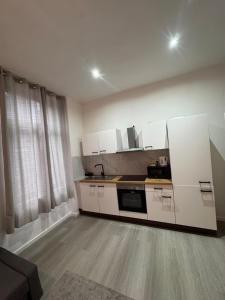 a kitchen with white cabinets and a counter top at Stylish 1BR Apartment with Sofa Bed in the Heart of Liège in Liège +4 photos