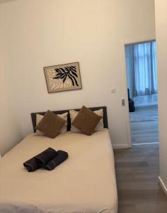 a bed with two pillows on it in a room at Stylish 1BR Apartment with Sofa Bed in the Heart of Liège in Liège