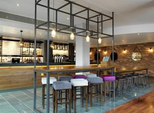 a bar with bar stools in a restaurant at Hilton Garden Inn Birmingham Brindley Place in Birmingham