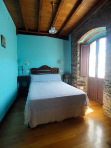 a bedroom with a white bed in a room with a window at Casa Venancio in Trabada