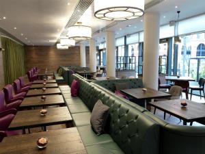 a restaurant with couches and tables and windows at Hilton Garden Inn Birmingham Brindley Place in Birmingham