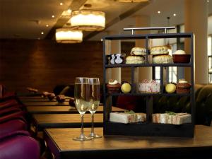 a table with a wine glass and a shelf of pastries at Hilton Garden Inn Birmingham Brindley Place in Birmingham