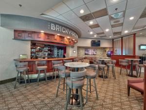 Eine Bar in einem Restaurant mit Barhockern in der Unterkunft DoubleTree by Hilton Bloomington in Bloomington