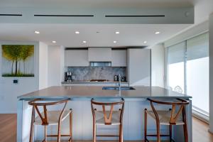 a kitchen with a large island with two bar stools at The Canadian in Vancouver