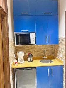 a small kitchen with blue cabinets and a microwave at Atlantis Hotel in Cairo +17 photos