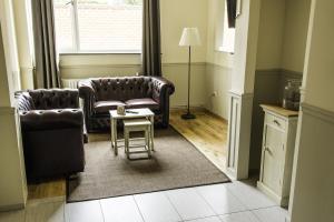 een woonkamer met 2 stoelen en een tafel bij Hotel Saint Georges in Bergen