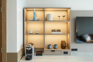 a shelf with various items on it next to a tv at The Sidney Pier Hotel in Sidney