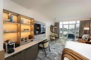a hotel room with a bed and a desk at The Sidney Pier Hotel in Sidney +110 photos