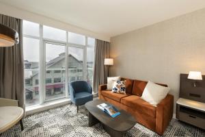 a living room with a couch and a large window at The Sidney Pier Hotel in Sidney