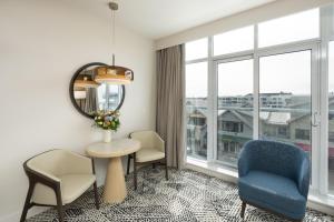 a living room with a table and chairs and a window at The Sidney Pier Hotel in Sidney