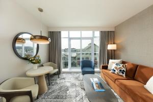 a living room with a couch and a table at The Sidney Pier Hotel in Sidney