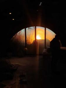 a person standing in a dark tunnel with the sunset in the window at Hostería Casa Angirû in Colonia Chapadmalal