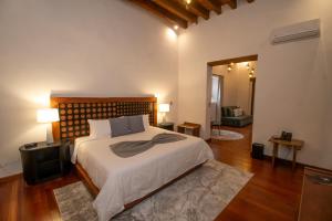 a bedroom with a large bed with a wooden headboard at Mirtala Hotel Boutique in Guanajuato