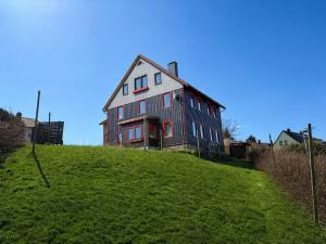 a house sitting on top of a grassy hill at Pension moos & morgenrot - St Andreasberg in Sankt Andreasberg